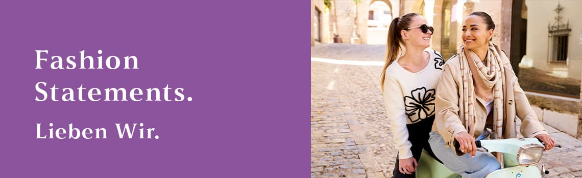 Fashion Statements. Lieben Wir. – Zwei Personen in modischer Kleidung sitzen auf einem Motorroller auf einer gepflasterten Straße