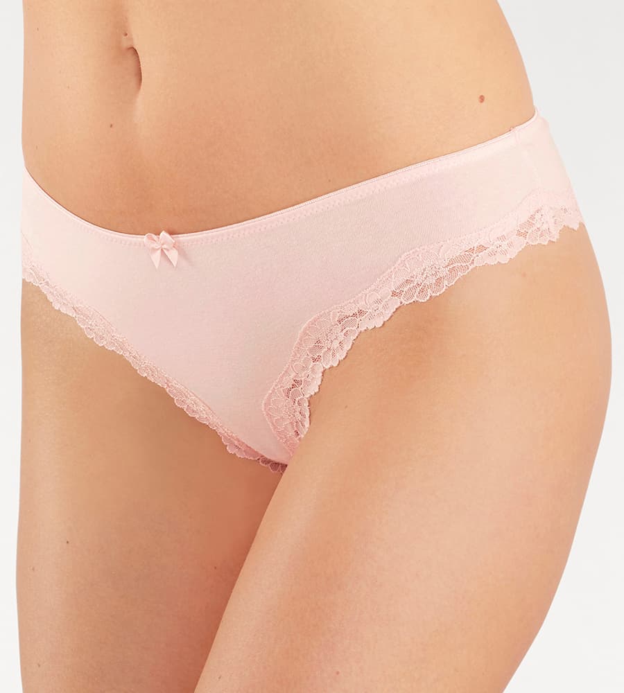 Model trägt einen rosafarbenen Slip mit Spitzenbesatz und kleiner Schleife vorne.