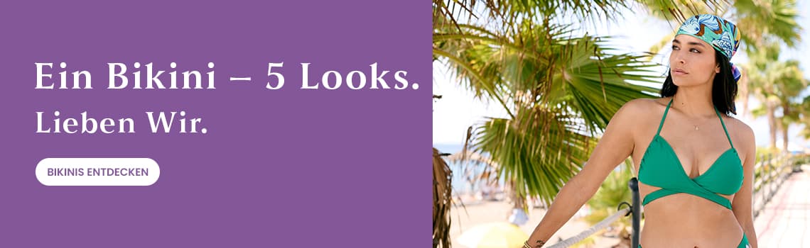 Ein Bikini – 5 Looks. Lieben Wir. Frau in grünem Bikini und Kopftuch steht vor Palmen und Strand.
