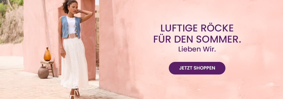 Luftige Röcke für den Sommer – Frau im langen weißen Rock und Jeansweste lehnt an rosa Wand, Button Jetzt shoppen