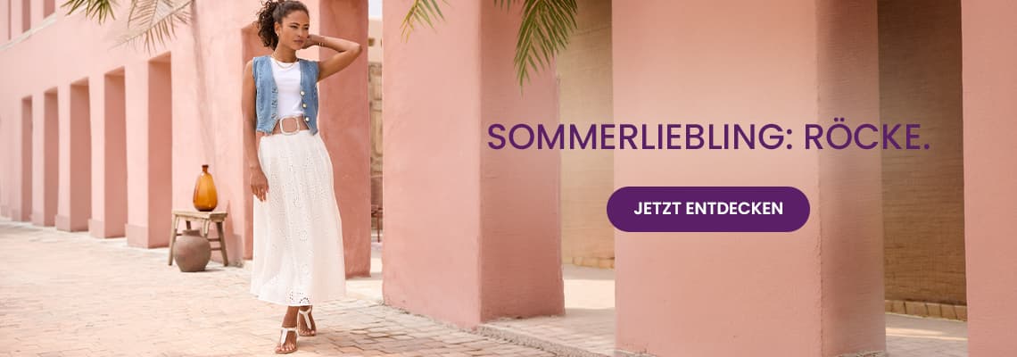 Sommerliebling: Röcke – Frau im weißen Maxirock und Jeansweste geht zwischen rosa Säulen, Button „Jetzt entdecken“