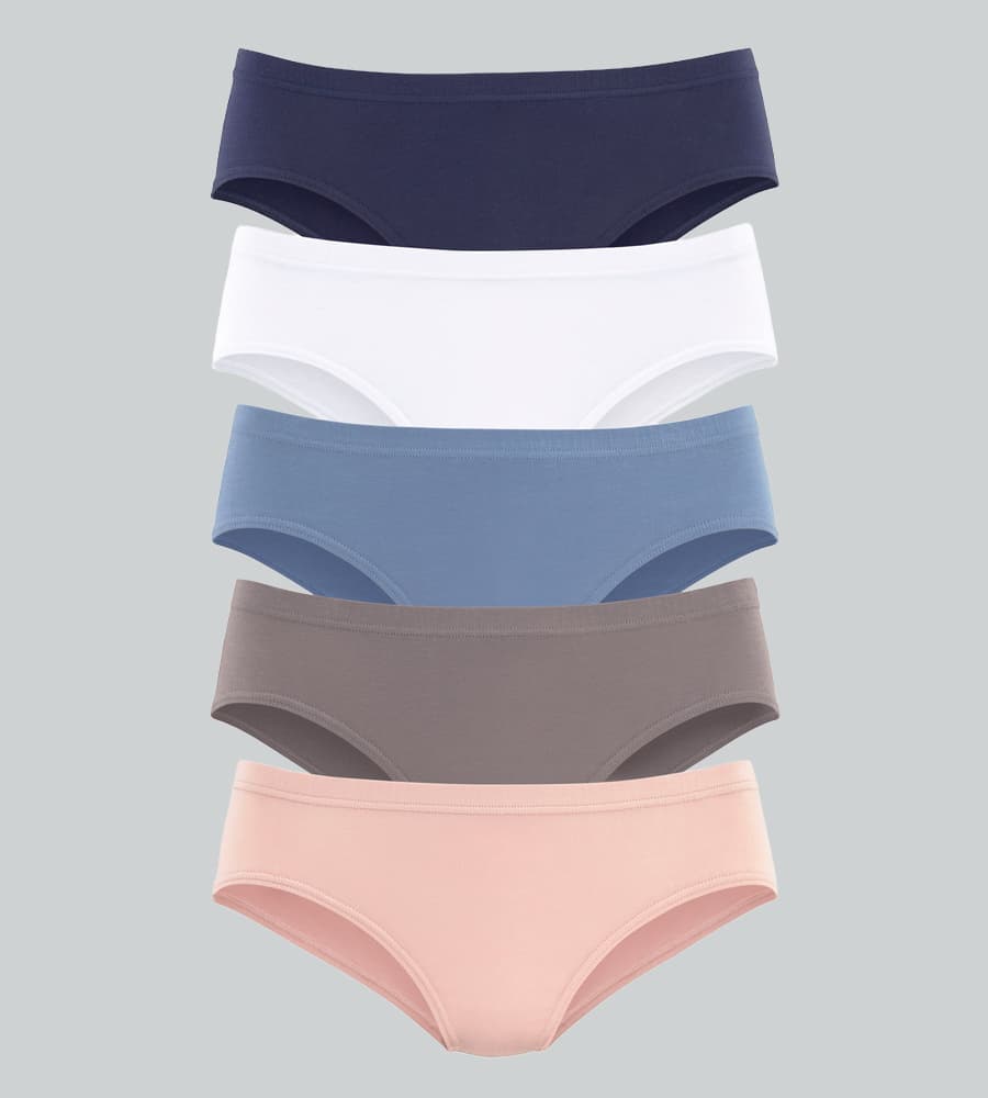 5 Slipshorts übereinander in Dunkelblau, Weiß, Hellblau, Taupe und Hellrosa vor grauem Hintergrund